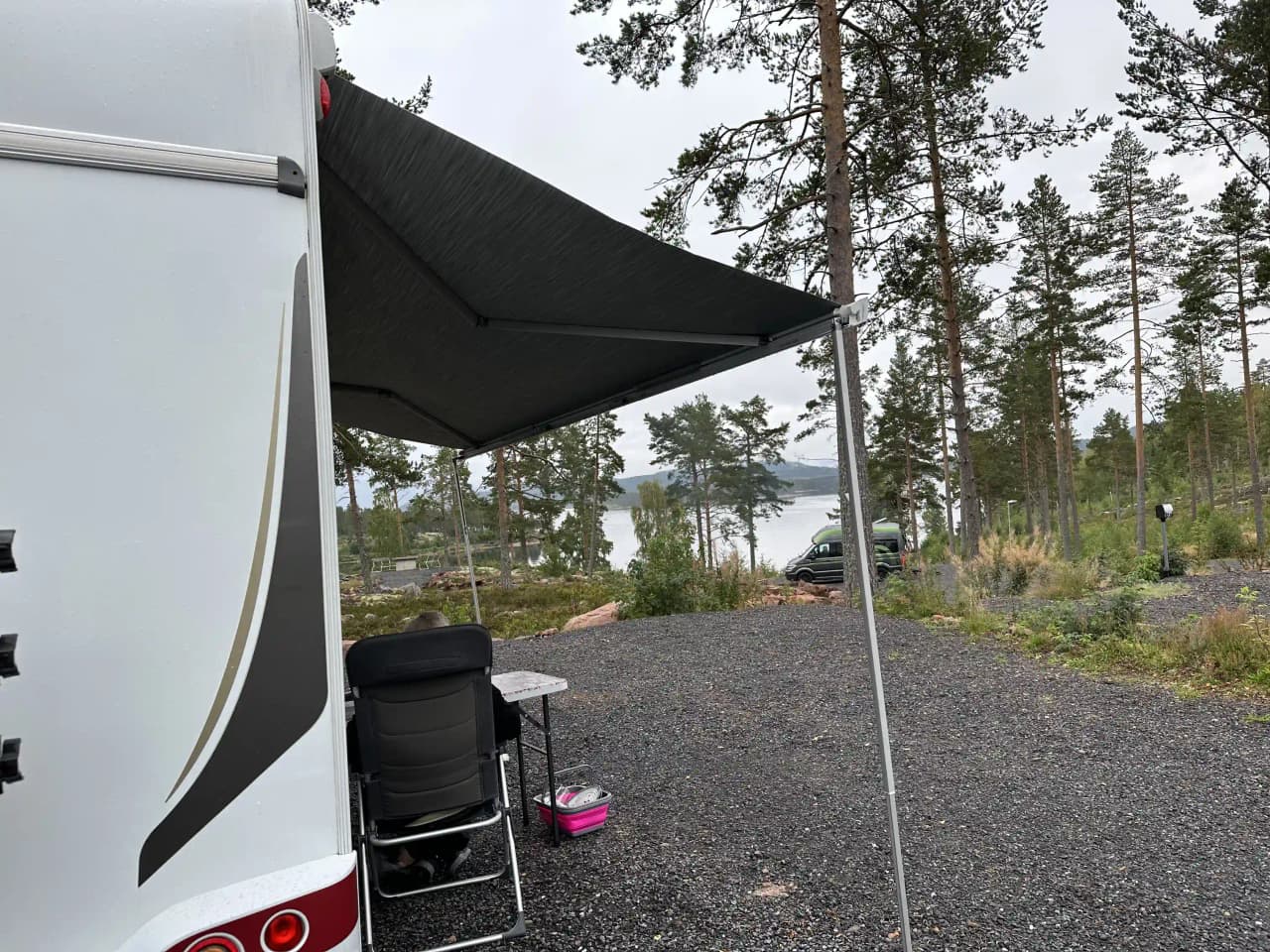 En husvagn parkerad vid Måvikens camping & naturområde, omgiven av grönska och friluftsmiljö.