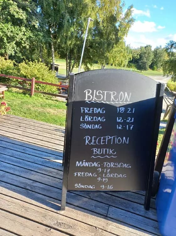 Bild av Gålö havsbad med utomhusmöbler, inklusive bord och stolar, som står på en terrass eller uteplats. Området ser inbjudande ut för en picknick eller en måltid i friska luften.