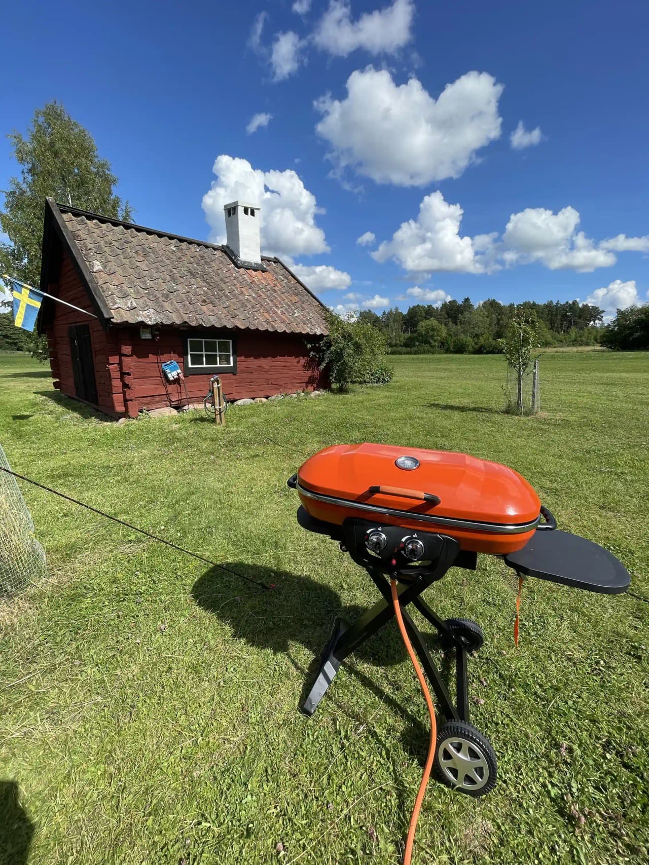 En utomhusgrill på Kvarngården Hembygdsgård, omgiven av grönska.