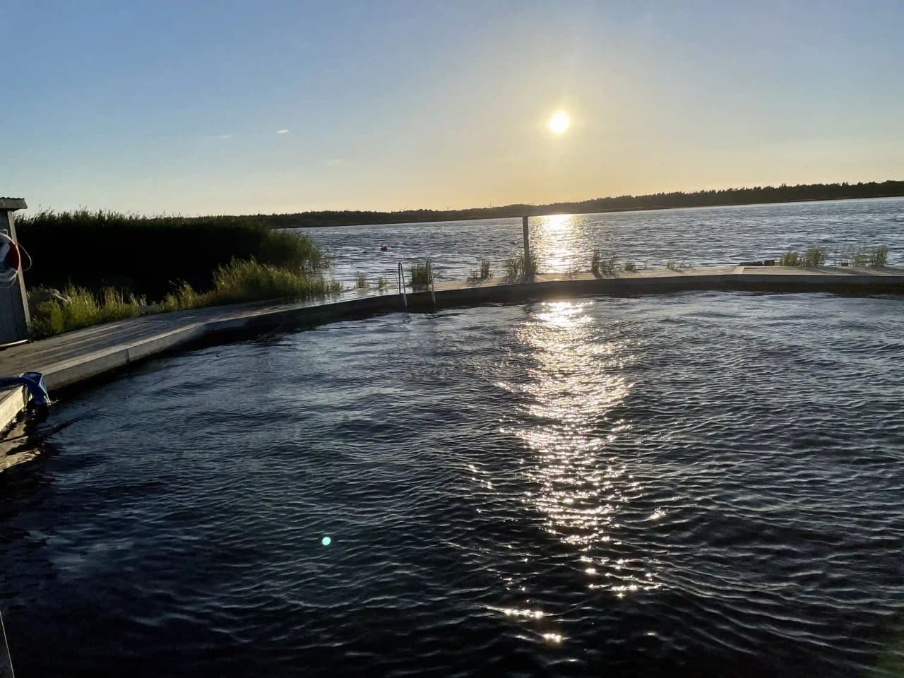 En bild av ett lugnt vattendrag vid Fide Äventyrsby & Camping, med spegelklara reflektioner som ger en känsla av fridfull rekreation och naturskön miljö.