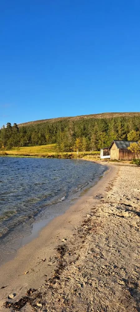 Sjöstugan vid vattnet med en vidsträckt horisont, omgiven av kustlinje och strand.