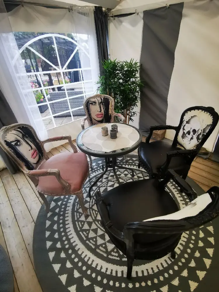 En elegant inredd inomhusmiljö med moderna grå stolar och ett soffbord, inbjuder till avkoppling och umgänge vid Bovikens Havsbad.