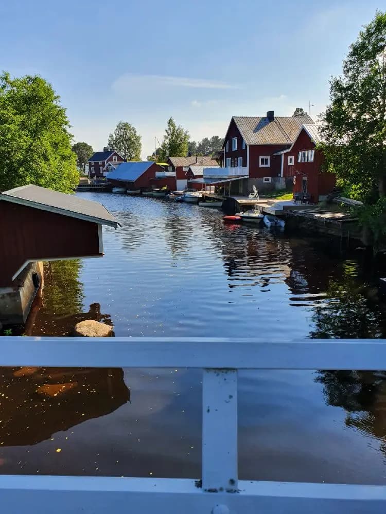 En lugn vattenväg vid Sörfjärdens camping med flera båtar som speglas i det stilla vattnet.