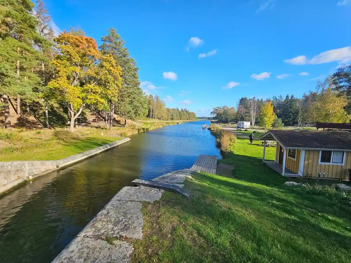 En naturskön vy över en flod omgiven av frodig grönska och träd vid Brådtom Lock Campground.