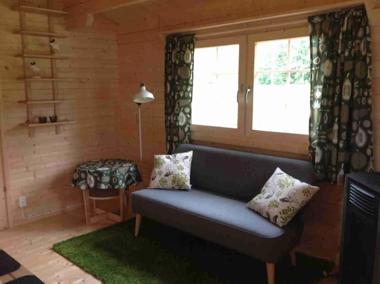 En varm och inbjudande campingstuga med träinredning, inklusive trägolv och möbler som ger en rustik och hemtrevlig känsla.