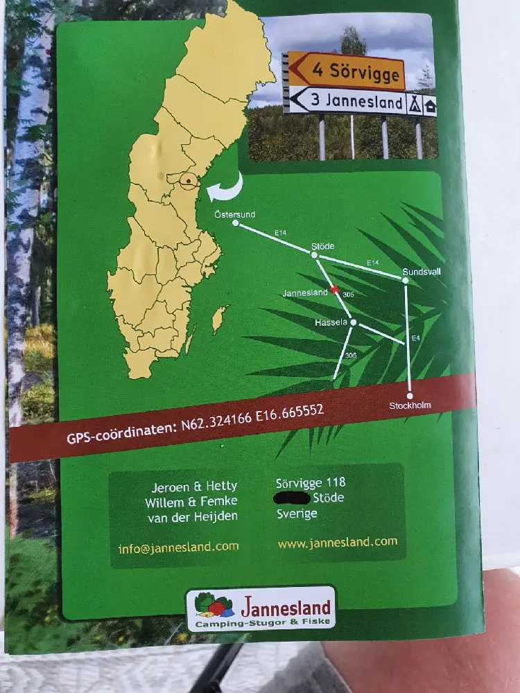 En reklamskylt vid ingången till campingområdet JanneSland. I bakgrunden syns grönska och campinganläggningens område.
