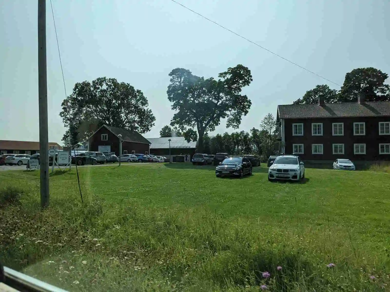 Bild på Vreten kursgård, med ett stort hus omgiven av en grön gräsmatta. I förgrunden syns en parkerad familjebil och i bakgrunden stiger fler hus ur det lugna bostadsområdet.