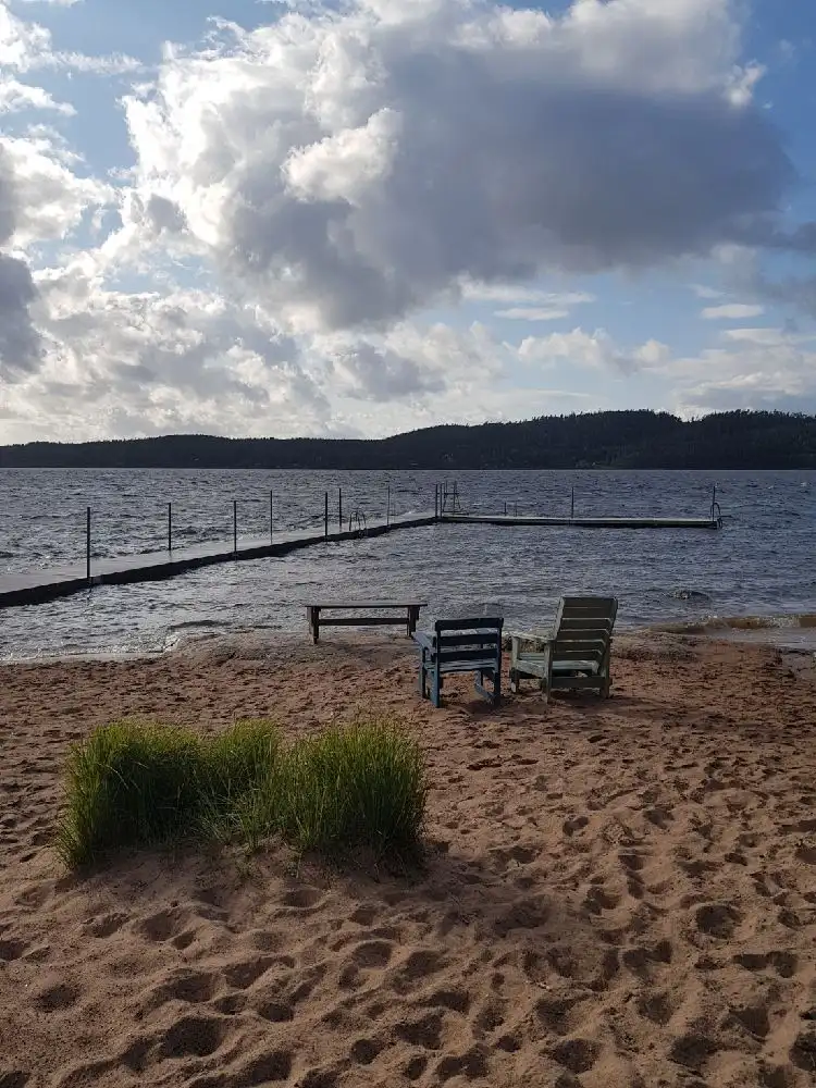 En somrig strandbild vid Lövekulle camping, med en blick mot horisonten där havet möter himlen.