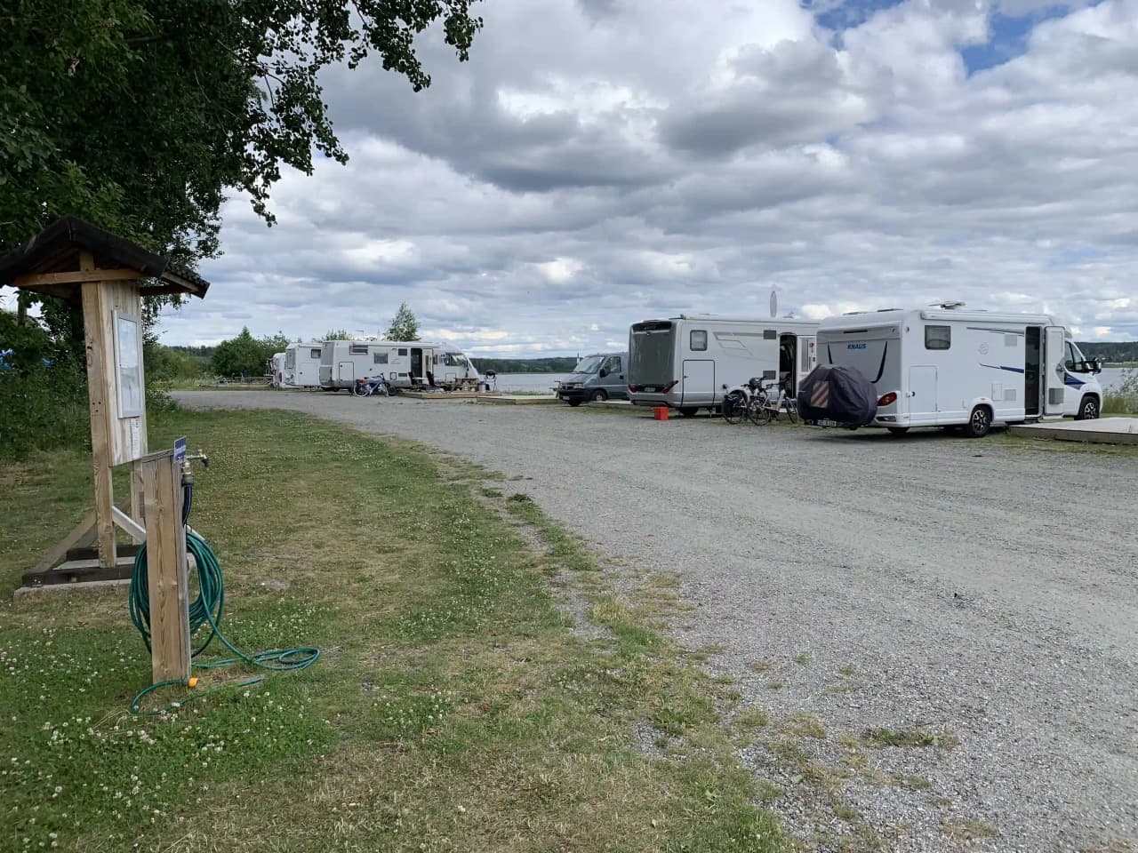 En molnig dag vid Arvika småbåtshamn med husbilar och bilar parkerade i området.