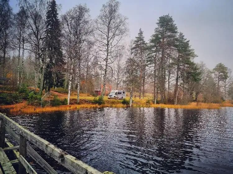 En naturskön vy vid Pankoviken i Kloten, med lugnt vatten omgiven av grönskande träd och växtlighet.