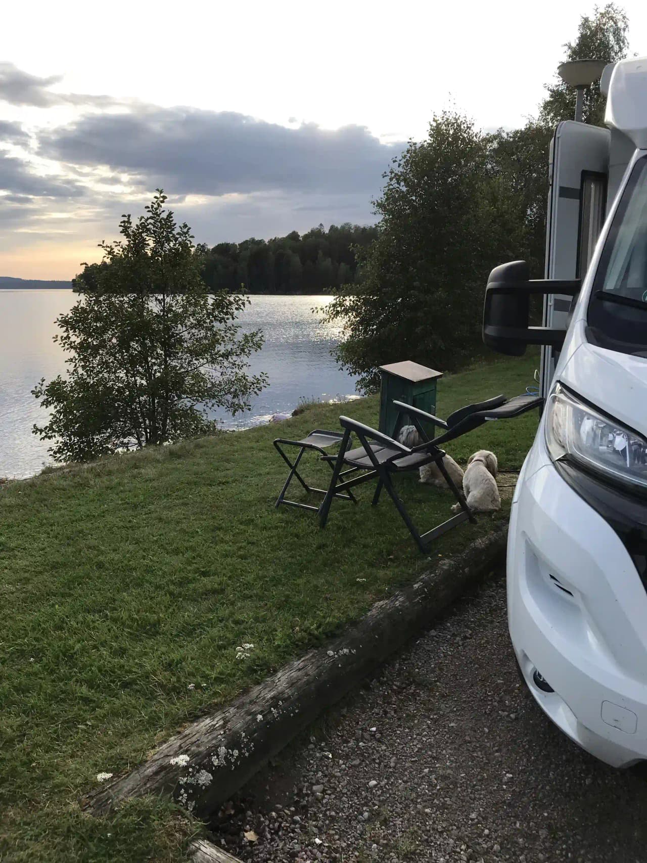 En husvagn och campervan står parkerade på Ekeby camping, omgivna av välskött gräsmatta.