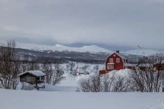 Snöklädda berg i ett vinterlandskap vid fjällnäs camping.