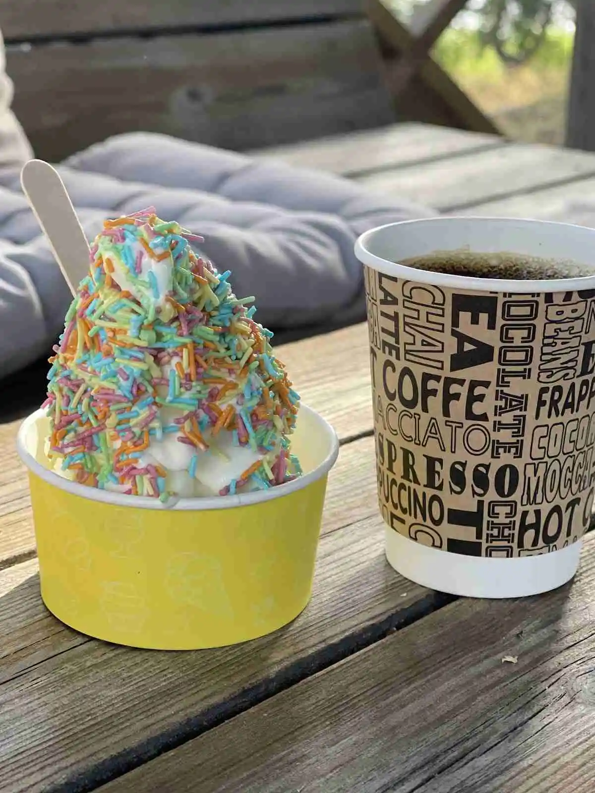 En glassbägare fylld med flera kulor gelato utanför Waxholms Camping, perfekt för en sommardag.