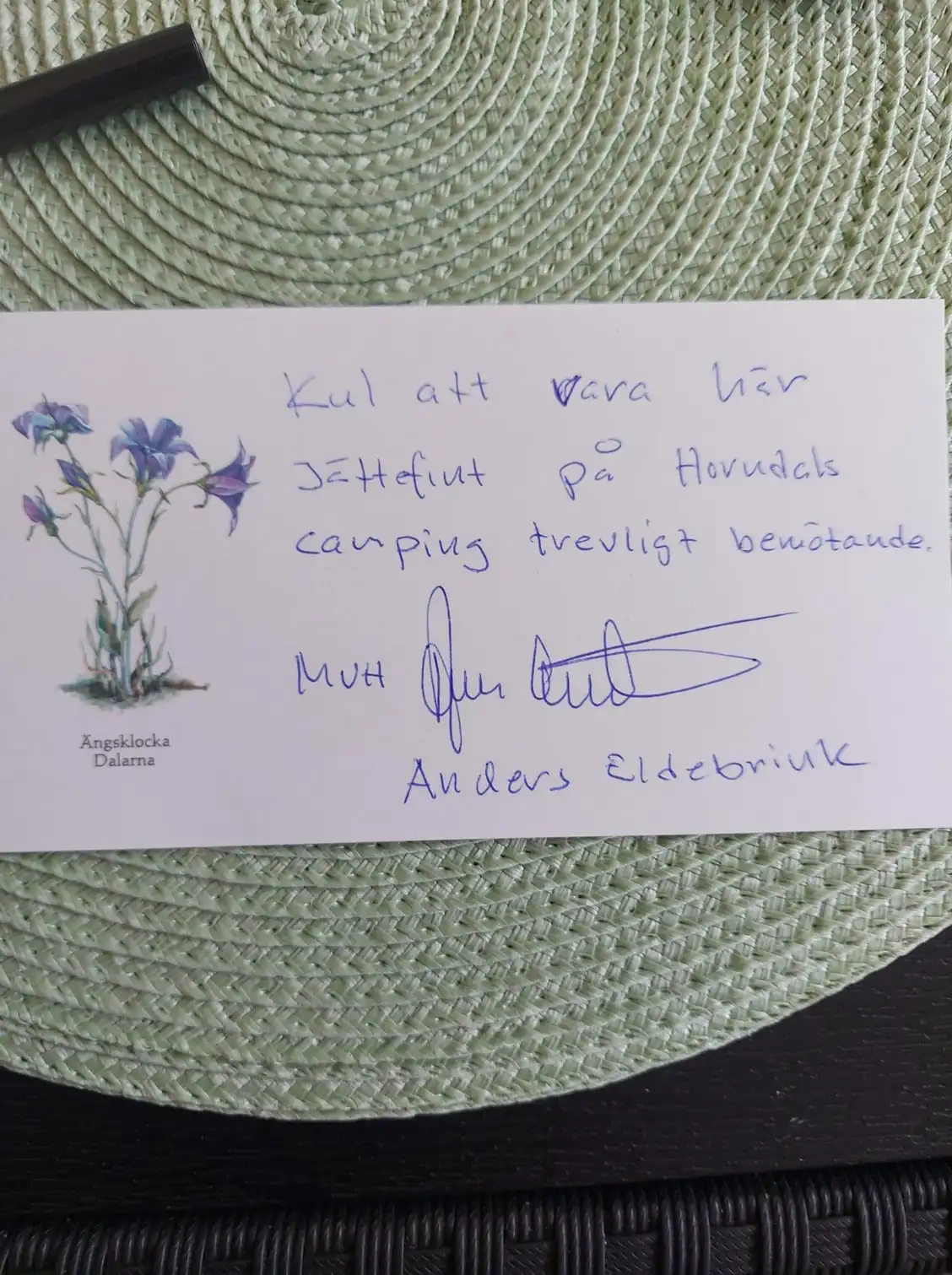 En hand håller ett papper med handskriven text på Horndals bad & camping.