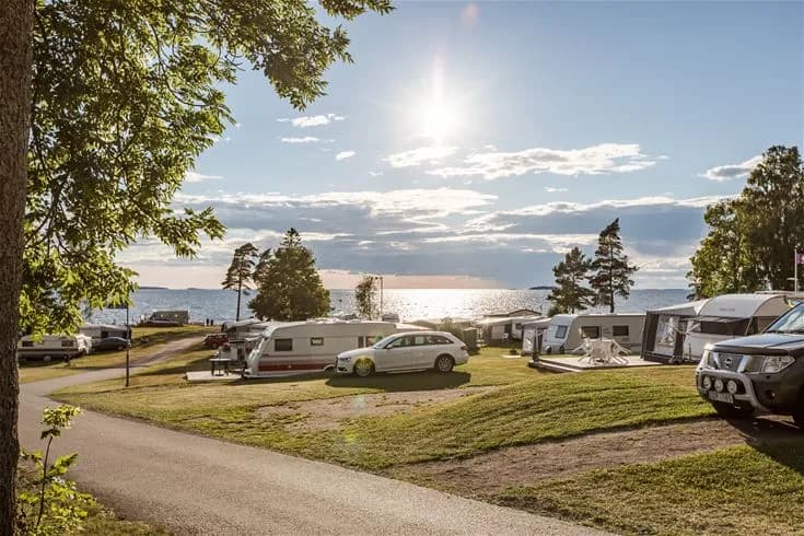 En husvagn parkerad på Askeviks camping & stugor omgiven av grönska.