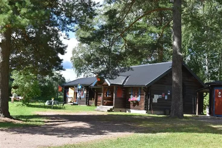 En naturskön campingplats med trädkantad grönska och stugor, en idealisk plats för rekreation och avkoppling.