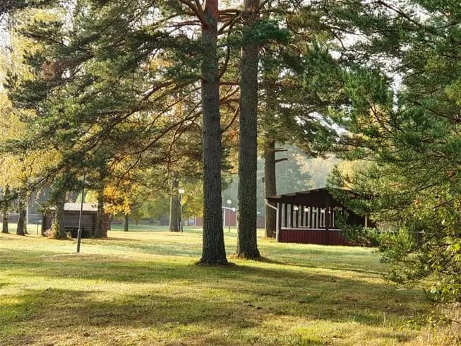En naturskön campingplats med gröna gräsmattor, omgiven av träd och vidsträckta landskap.