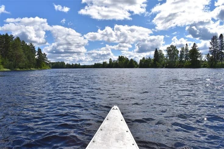 En klarblå sommardag vid en sjö med moln på himlen och vacker naturlig omgivning vid Nås camping.