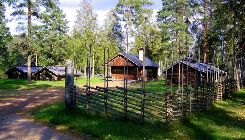 En mysig stuga omgiven av tät skog vid Älvdalens camping, med en träkonstruktion och ett sluttande tak, belägen i ett fridfullt och naturnära område.