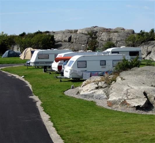 Bild på en parkeringsplats vid Hav & Logi Skärhamn med flera fritidsfordon och husbilar parkerade.