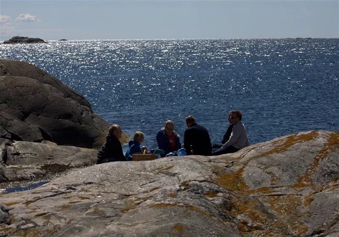 En bild av en kustlinje vid Hav & Logi Skärhamn, som visar klippformationer och terräng vid havet med synlig berggrund och utsikt mot havet.