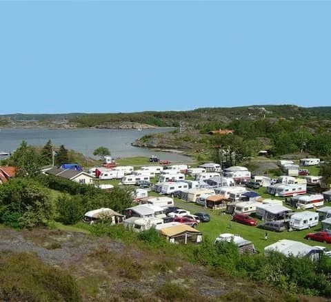 En campingplats med husbilar parkerade vid en naturskön vik i Lake District.