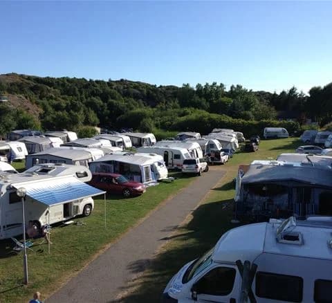 En parkeringsplats vid Malö camping med flera husbilar och husvagnar uppställda.