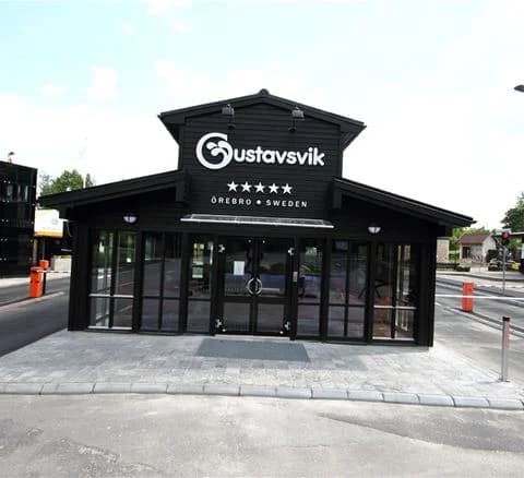 En bild av Gustavsvik Resort, där en logotyp för anläggningen och en byggnad som liknar ett värdshus syns.