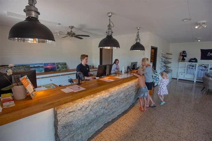 En campingplats med en stugby, där en stol och en bänkskiva är synliga.