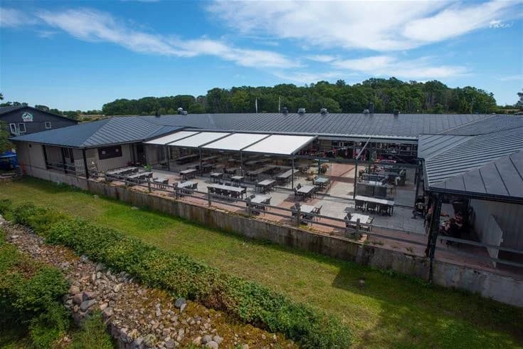 En skuggig utomhusstruktur vid Lundegård Camping & Stugby, med en pittoresk atmosfär som inbjuder till avkoppling och gemenskap.