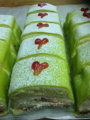 En härlig bild av en schweizisk rulltårta på Lundegård Camping & Stugby, perfekt dekorerad och serverad som efterrätt, inbjuder besökare att njuta av nybakat och hemlagat fika.