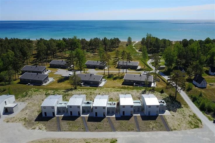 Flygfoto över Sudersand Resort som visar en stor grön markyta och omgivande landskap.