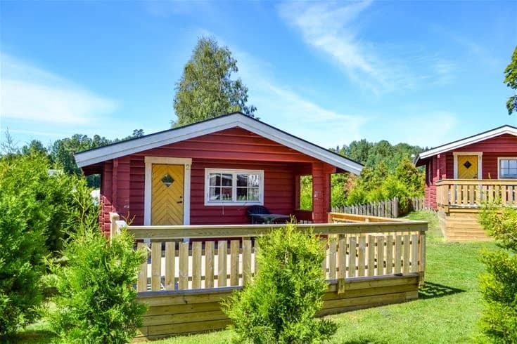 En timrad stuga i naturskön miljö med en välskött trädgård. Grönska omger stugan och bildar en avkopplande atmosfär på Charlottenberg camping & stugor - Haganäset.