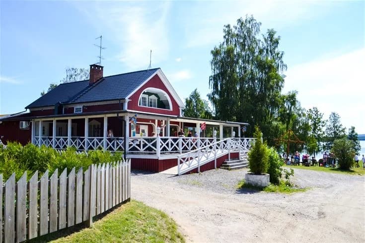 Bild av Charlottenberg camping & stugor - Haganäset, med en mysig stuga och omgiven av grönska.