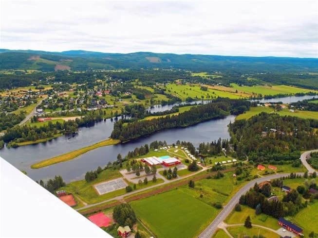 Flygbild över Stöde Camping visar en naturskön miljö med vattenvägar och omgivande grönska.