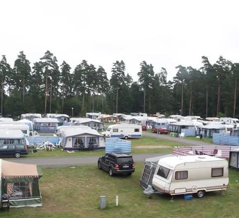 En parkeringsplats vid Bromölla camping & vandrarhem med flera uppställda husbilar.