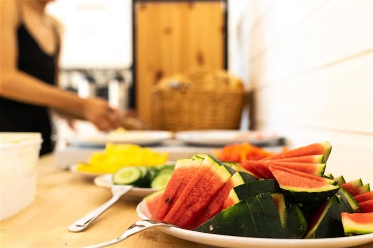 En skål med färsk frukt, inklusive vattenmelon och melon, står på ett bord i Haga Park Camping & Stugor.