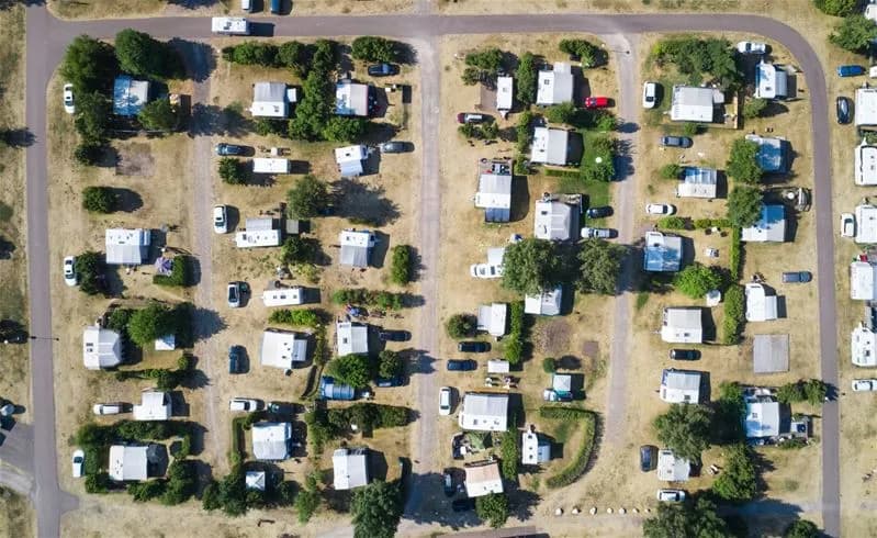 Flygbild över Haga Park Camping & Stugor, med landskap, parkering och angränsande bostadsområden i bakgrunden.
