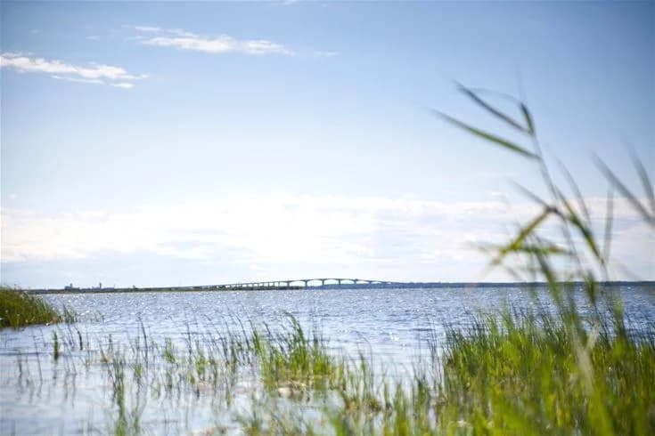 En klar himmel över ett vidsträckt vattenlandskap vid Saxnäs Camping, perfekt för naturälskare och friluftsaktiviteter.
