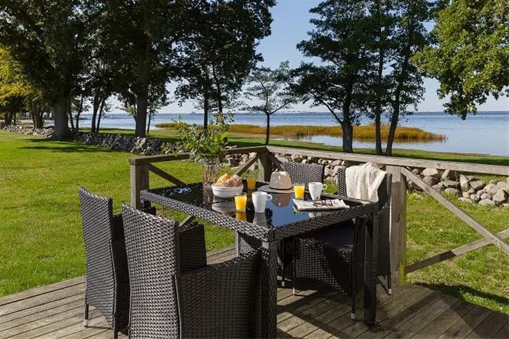 En uteplats vid Saxnäs camping med möbler som inkluderar stolar och bord under ett skuggande tak.