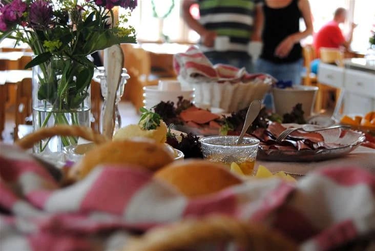En inbjudande gemensam frukostbuffé dukad på Eksjö Camping & Konferens med färsk frukt, porslin och dryckesglas på ett träbord.
