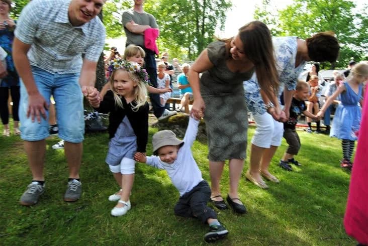 En grupp människor som har roligt utomhus på Eksjö camping & konferens på sommaren, iklädda avslappnade kläder som jeans och sommarskor.
