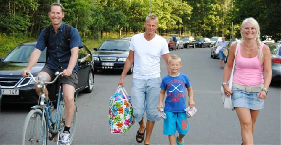 En sommardag på Eksjö Camping & Konferens där människor cyklar och njuter av fritidsaktiviteter. Flera personer cyklar med kortbyxor och cyklarna har synliga hjul och styren.