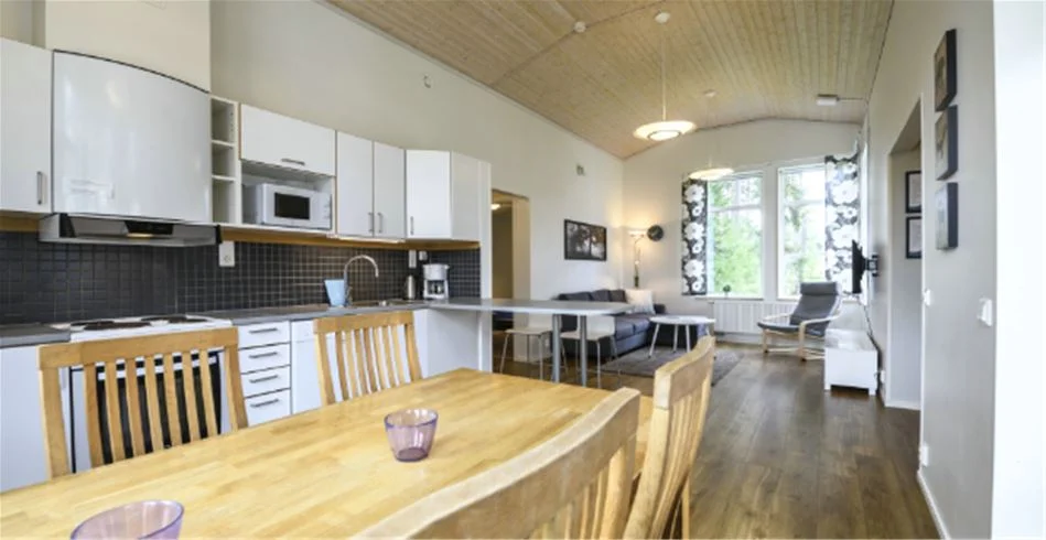 En mysig trästuga på Östersunds camping med hemtrevlig interiör, inklusive träinredning och trägolv, som skapar en varm och inbjudande atmosfär.