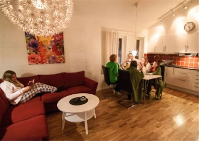 Ett modernt inrett vardagsrum på Skellefteå camping, med en bekväm soffa, trägolv och stilfull belysning.