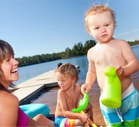 En glad och lekfull scen vid Orsa Grönklitt, där små barn njuter av sin semester genom att leka med leksaker och flaskor i en avkopplande miljö.