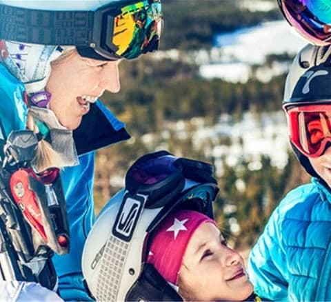 En person med skidutrustning och skyddsglasögon ler medan de bär hjälm och vinterjacka, men en vintertur i Orsa Grönklitt.