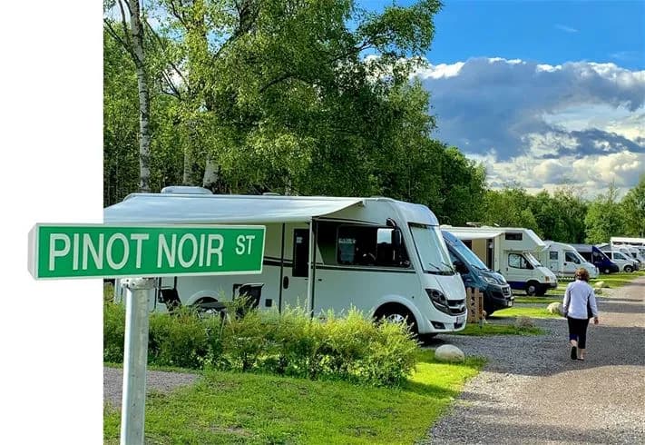 En husbil parkerad bland gröna träd på en campingplats i Överhörnäs.