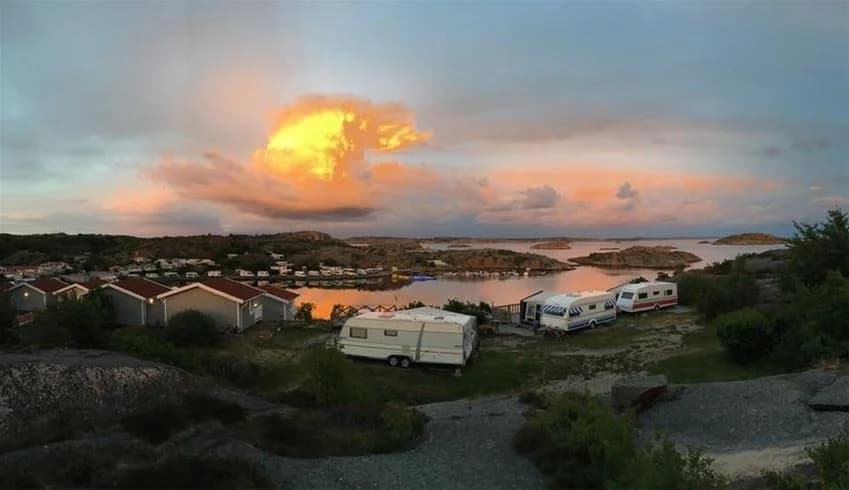 En vacker skymning vid kusten vid Wiggersviks camping, med en rödaktig himmel över viken och stilla vatten.