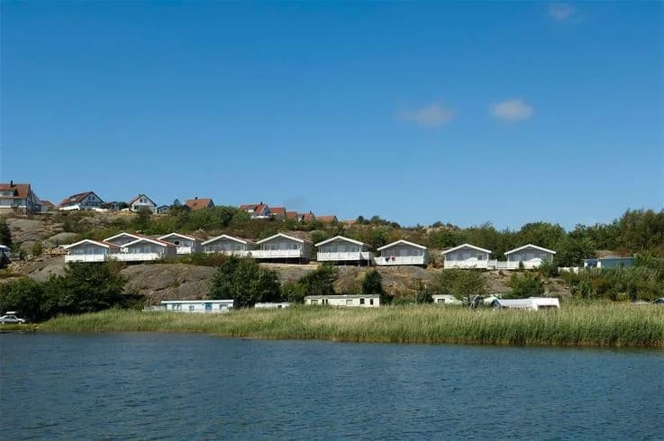 En pittoresk stuga vid kusten med utsikt över en lugn vik och omgiven av naturskönhet.